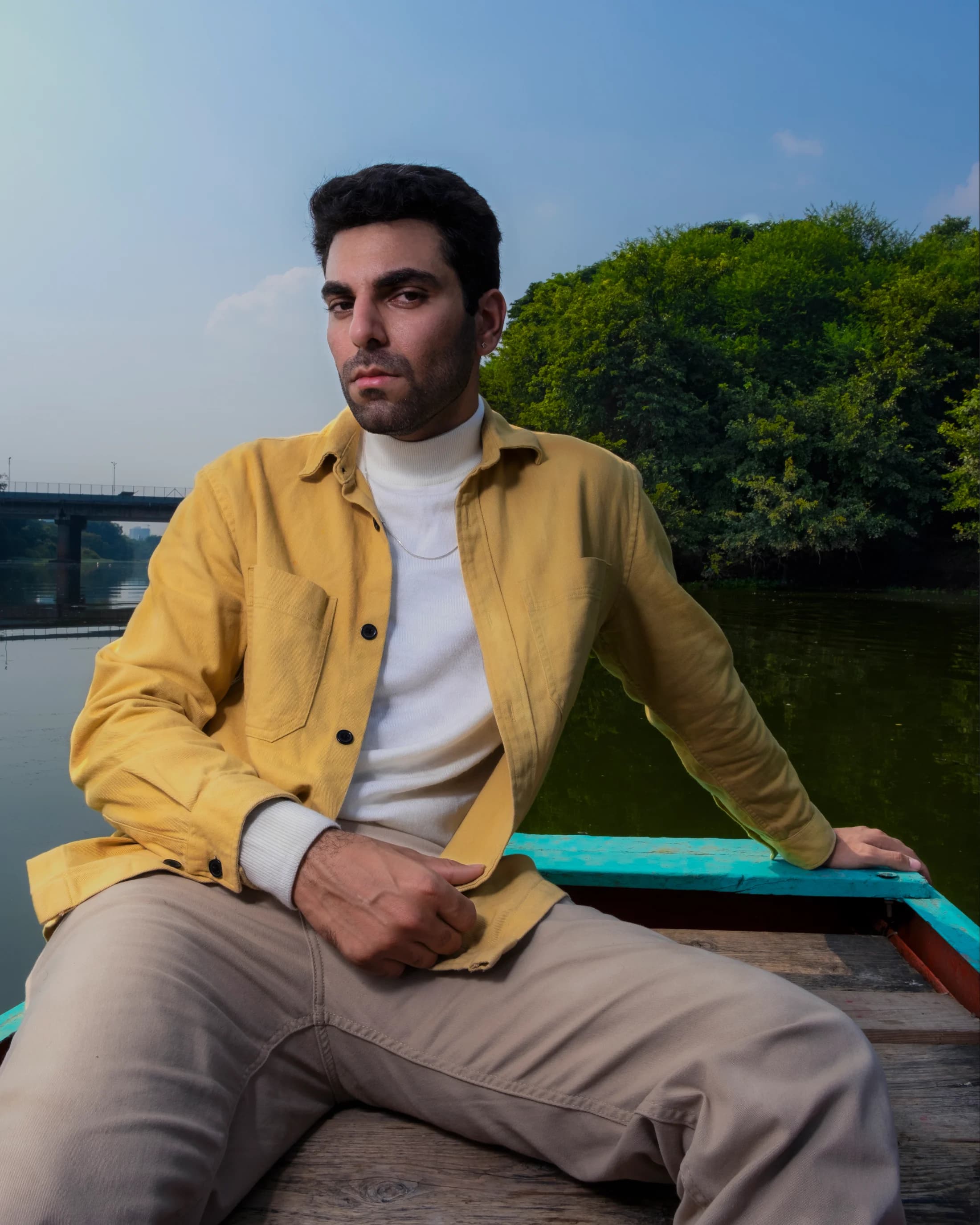 Portrait in a mustard jacket aboard a turquoise boat